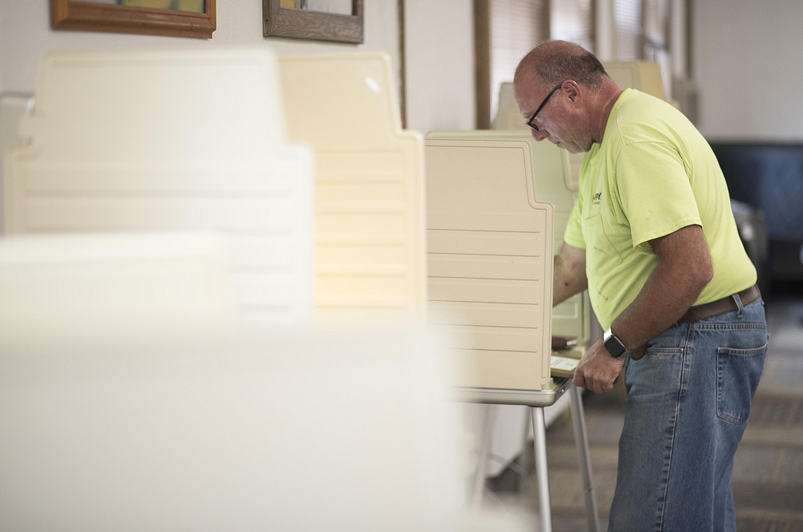 Terry Oedewaldt reads over a mill levy ballot -- a tax which would help fund a Student Resource Officer for the Libby Public School -- before turning in her vote, Tuesday in the school&#146;s administration building. (Luke Hollister/The Western News)