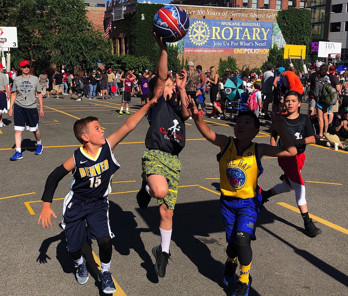 JASON ELLIOTT/Press
Capparelli Espresso's Cooper Miller splits the defense of Dream Team DJMB during an opening round Male Youth Division game at Hoopfest in Spokane.