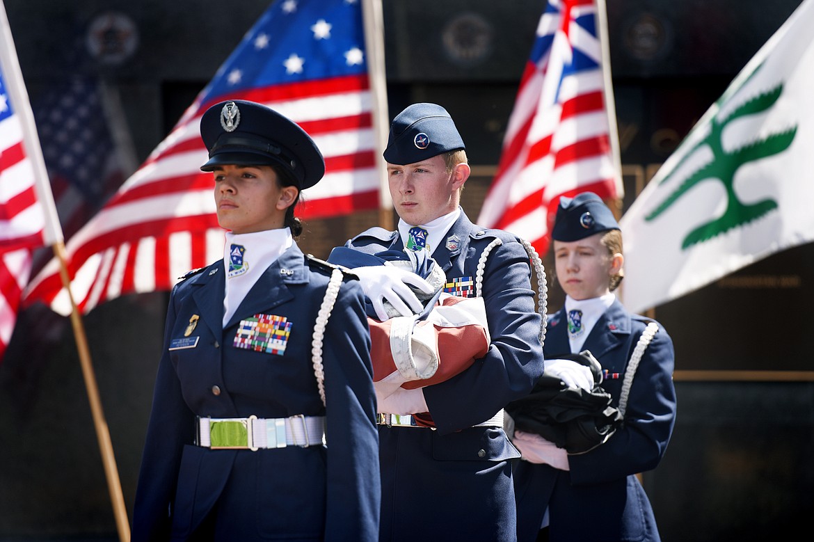 From left, Cadet Colonel Shelby Petersen, Cadet Chief Master Sergeant Daniel Dorsett Jr. and Cadet Senior Airman Joelle Roberson, with the Civil Air Patrol, present flags to be retired during a Flag Day ceremony at Depot Park in Kalispell on Friday. (Casey Kreider/Daily Inter Lake)