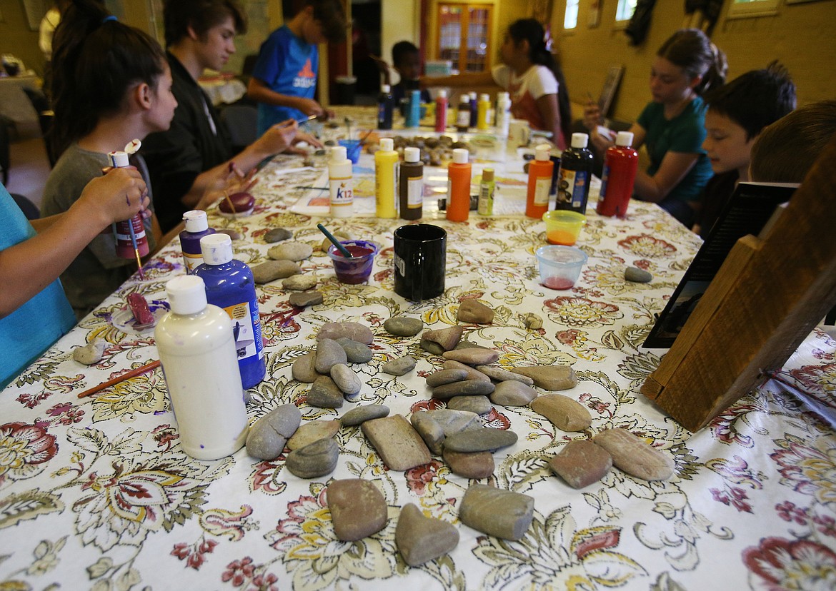 Students paint rocks with colors and cultural symbols at a multicultural camp Monday at the Human Rights Education Institute. (LOREN BENOIT/Press)