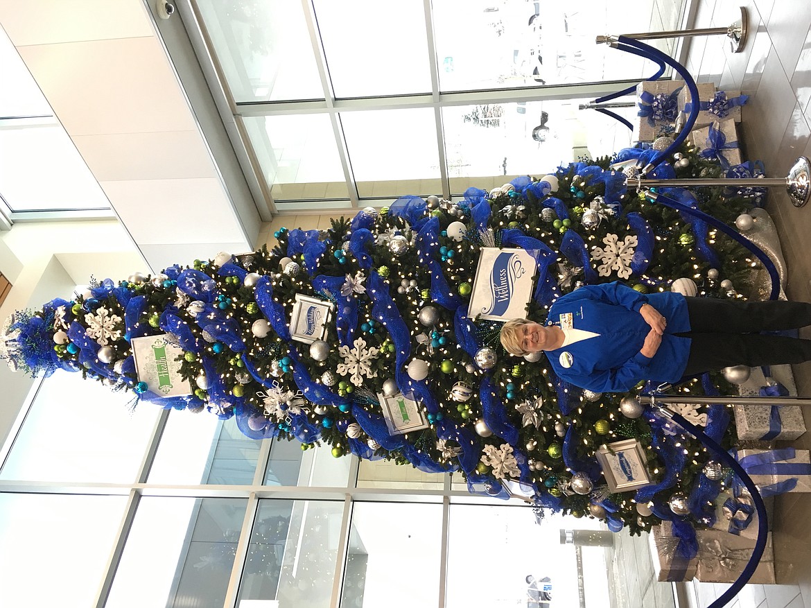 Volunteers such as Susan Riess (pictured) decorate the giant Christmas tree at Kootenai Health. (Courtesy Photo)