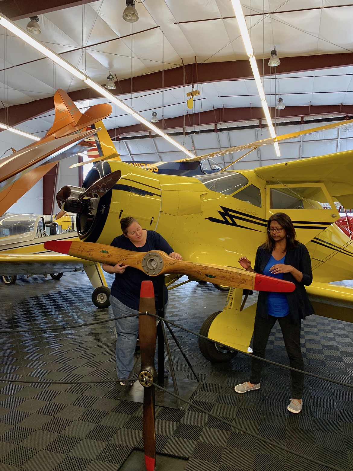 Bird Museum Director Rachel Schwam shows visitor Rini Paiva signatures of nationally famous inventors on a wooden propellor, including that of another local inventor-aviator, Burt Rutan (SHOLEH PATRICK/Press).