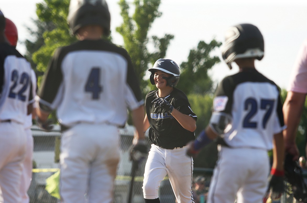 Coeur d&#146;Alene&#146;s Kyle Johnson smiles as he approaches home plate to celebrate his home run with his teammates in a game against Post Falls on Friday.