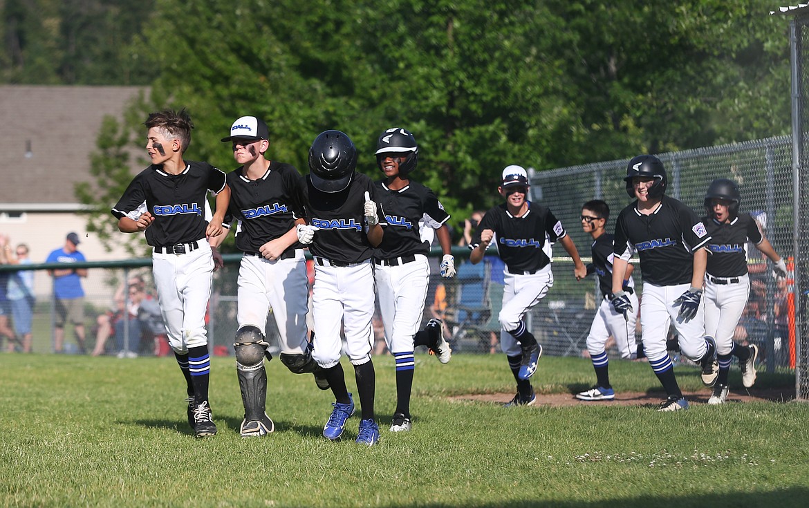 The Coeur d&#146;Alene Majors All-Stars rush to home plate to celebrate Kyle Johnson&#146;s home run against Post Falls last Friday at the Canfield Sports Complex.