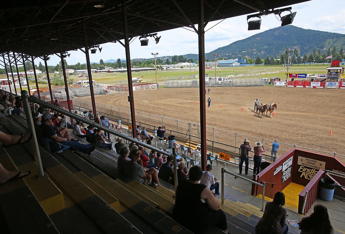 Spectators watch a competitor and his horses weave through cones during the logskid competition at Friday's  Idaho State Draft Horse and Mule Show at the Kootenai County Fairgrounds. (LOREN BENOIT/Press)