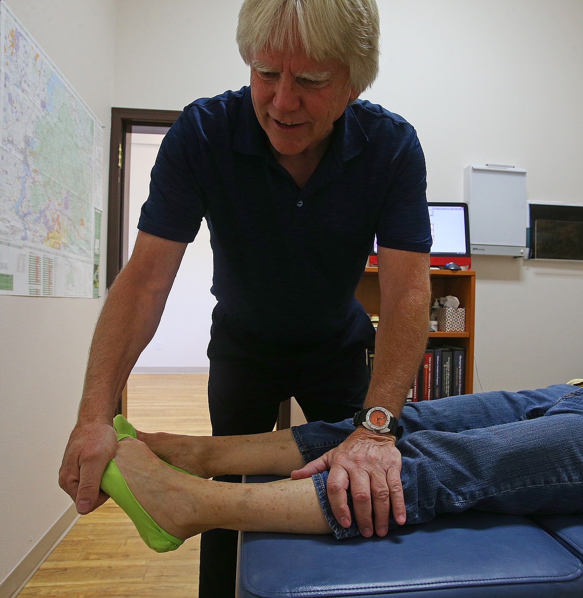 Dr. Dennis Brittain helps adjusts Fran Roads' feet during an appointment Wednesday at Brittain Chiropractic. (LOREN BENOIT/Press)