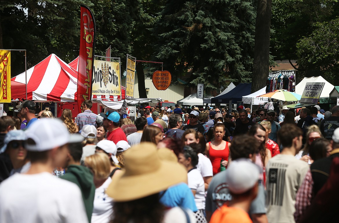 Scores of people walk up and down a walkway in City Park to find a bite to eat during Fourth of July. (LOREN BENOIT/Press)