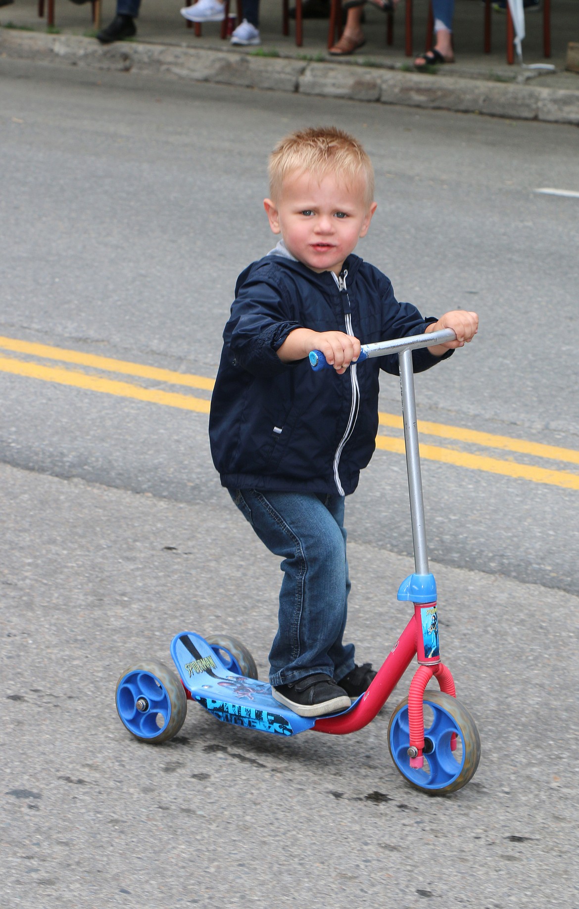 (Photo by CAROLINE LOBSINGER)A young parade participant makes his way down First Avenue during Thursday's Fourth of July Grand Parade.