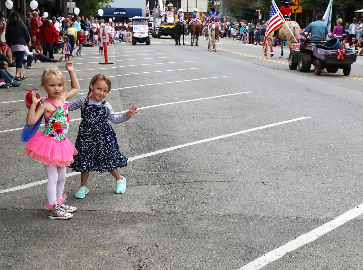 (Photo by CAROLINE LOBSINGER)A pair of parade watchers dance to the passing music as they enjoy the Sandpoint Lions' Grand Parade on Thursday. Dozens of floats and thousands of people packed the parade route on the Fourth of July.