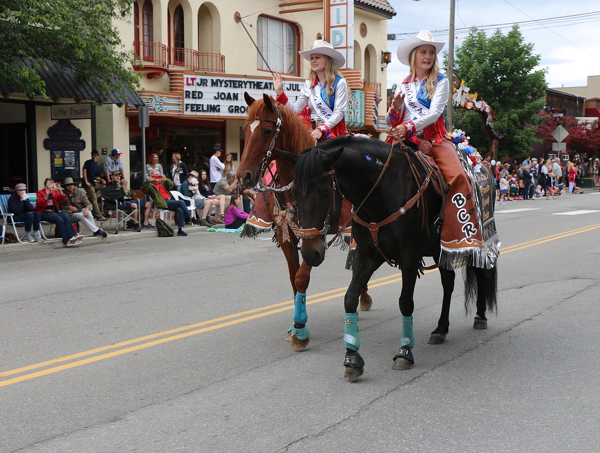 (Photo by CAROLINE LOBSINGER)Bonner County Rodeo royalty wave to the crowds as they ride down First Avenue during Thursday's Grand Parade, held each year by the Sandpoint Lions Club.