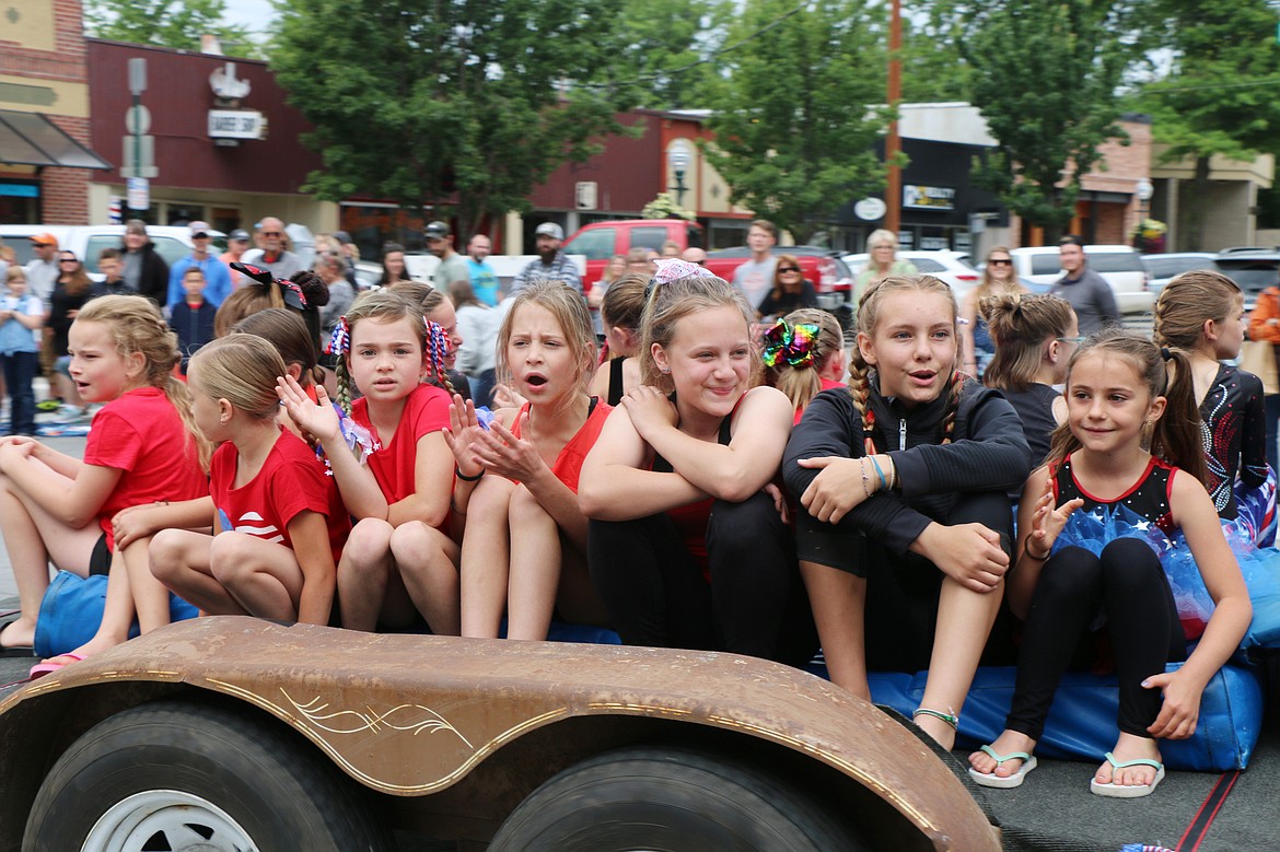 (Photo by CAROLINE LOBSINGER)Parade participants wave to crowd during Thursday's Grand Parade.