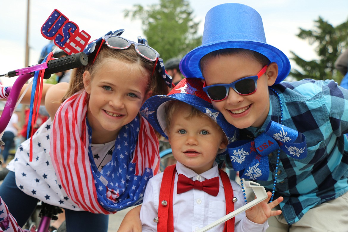 (Photo by CAROLINE LOBSINGER)A young trio pose for the camera as they wait for the start of the Sandpoint Lions' Fourth of July Kids Parade on Thursday.