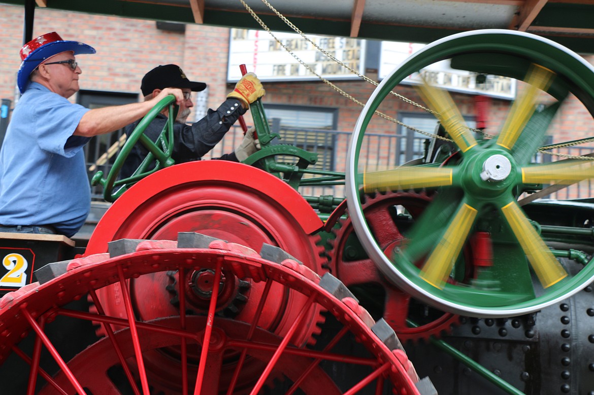 (Photo by CAROLINE LOBSINGER)Parade partcipants manuever their antique engine down First Avenue during Thursday's Fourth of July Grand Parade.