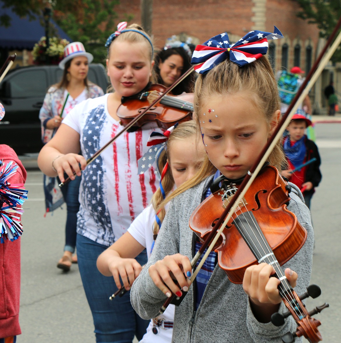 (Photo by CAROLINE LOBSINGER)Members of the Suzuki String Academy perform a tune during the Sandpoint Lions' Kids Parade on Thursday.