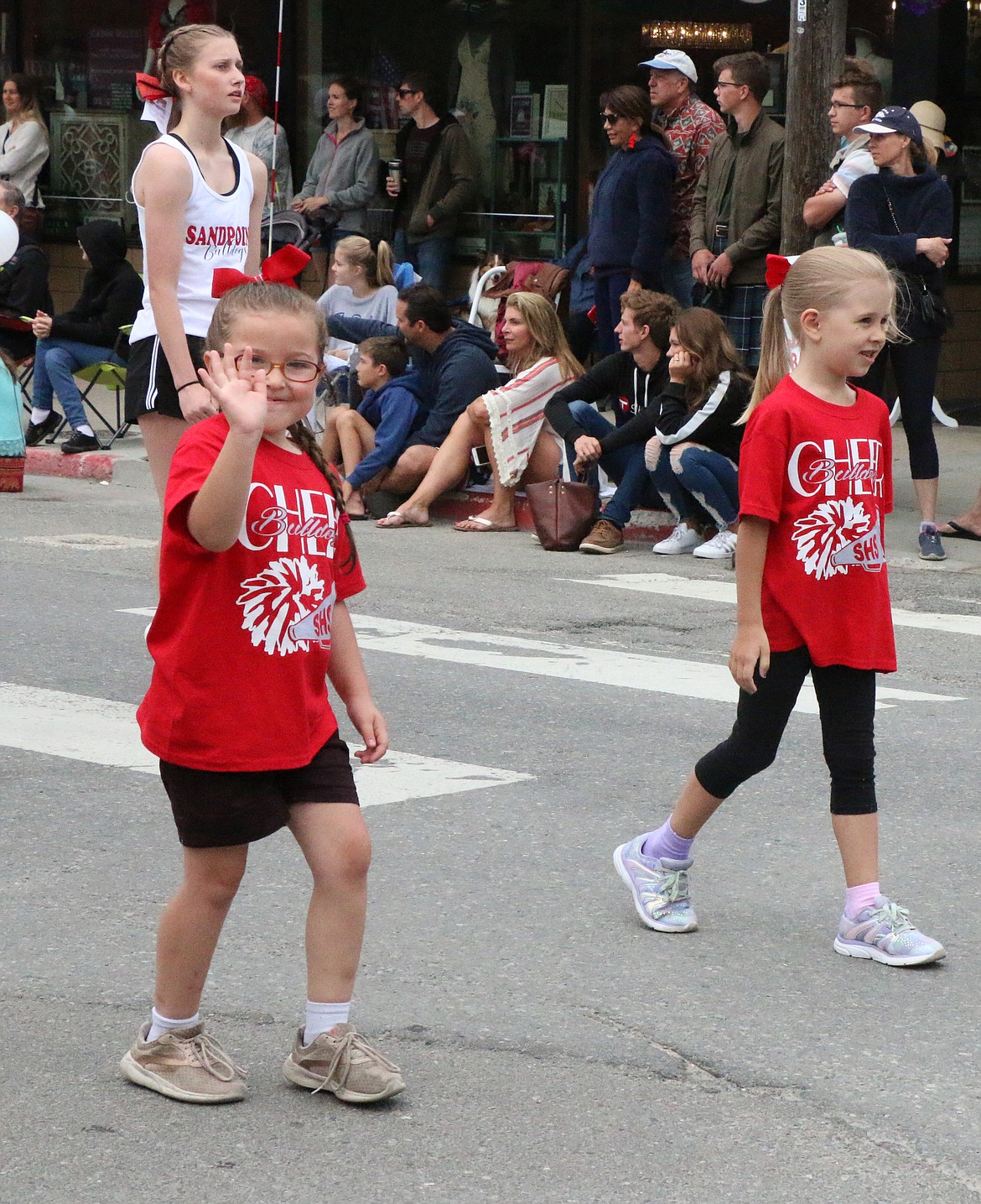 (Photo by CAROLINE LOBSINGER)A pair of Sandpoint High School Cheer Camp participants have fun during the Grand Parade on Thursday.