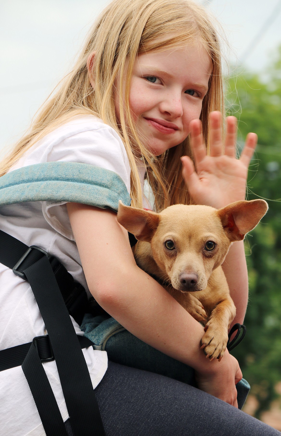 (Photo by CAROLINE LOBSINGER)A young Panhandle Animal Shelter supporter and friend wave to the crowd during the Grand Parade on Thursday.