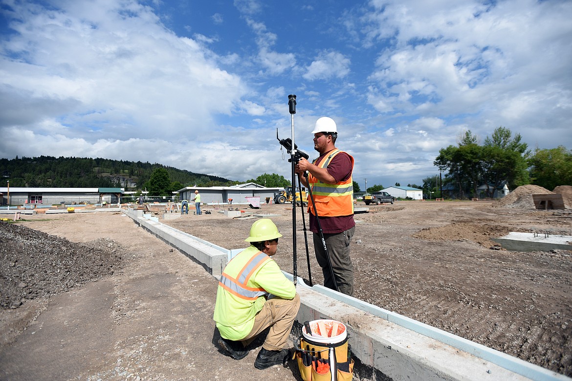 Chance Borden, right, and Ron Gardner, with TD&amp;H Engineering, survey and mark out gridlines for the foundation at Somers Middle School on Wednesday, July 3. (Casey Kreider/Daily Inter Lake)