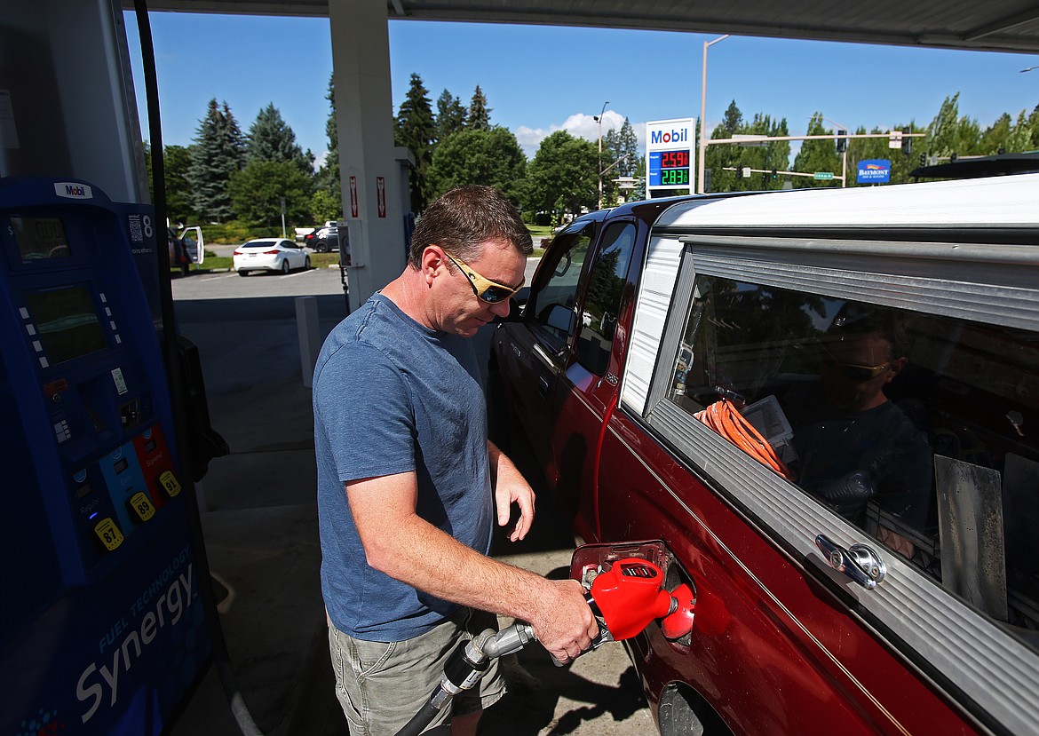Ben Mathew, of Coeur d&#146;Alene, fills up his truck with gas at the Mobil 1 stop at the end of Sherman Avenue Tuesday morning. Local gas prices have dropped 30 cents from a month ago and AAA expects prices to level off soon. (LOREN BENOIT/Press)