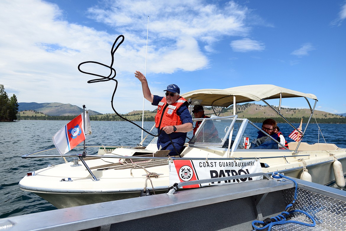 Chris Roberts  tosses a rope to tow a boat in distress during a patrol demonstration on Flathead Lake near Big Arm.