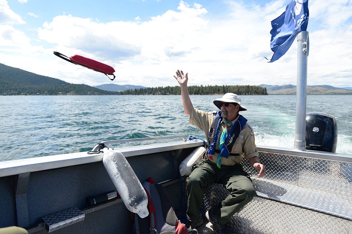 Bob Edgar, with the Bitterroot District of the Boy Scouts of America, tosses a flotation device representing a man overboard during a man overboard drill while on a patrol demonstration on Flathead Lake near Big Arm on Tuesday, June 25. (Casey Kreider/Daily Inter Lake)