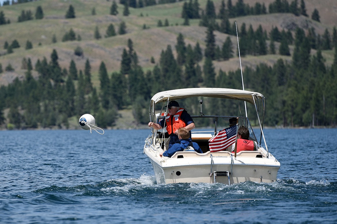 Chris Roberts, U.S. Coast Guard Auxiliary Flotilla Staff Officer, tosses a bouy overboard during a man overboard drill on Flathead Lake near Big Arm on Tuesday, June 25. (Casey Kreider/Daily Inter Lake)