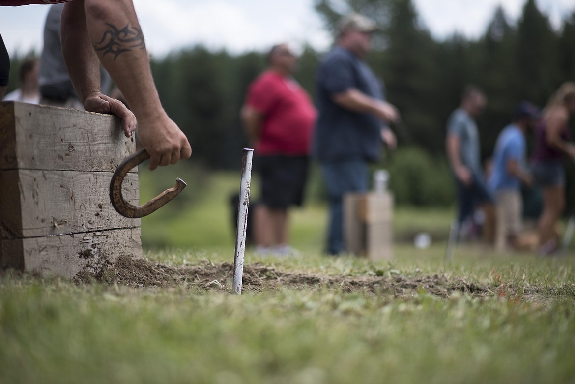 A horseshoe competitor prepares to throw after a horseshoe nearly hit their stake, Saturday at the Yaak River Mercantile and Tavern. (Luke Hollister/The Western News)