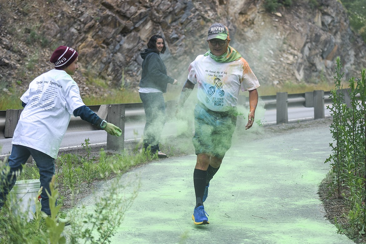 Elliott Crowe gets Lester Kawasaki -- a recent transplant to Libby from Colorado -- with green chalk as Laura Crowe looks on, during the PTA Fun Run, part of Troy&#146;s Old Fashioned 4th of July Thursday. (Ben Kibbey/The Western News)