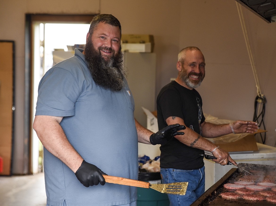 Troy City Council Members T.J. Boswell and Chuck Ekstedt took a shift flipping burgers during Troy&#146;s Old Fashioned 4th of July Thursday. (Ben Kibbey/The Western News)