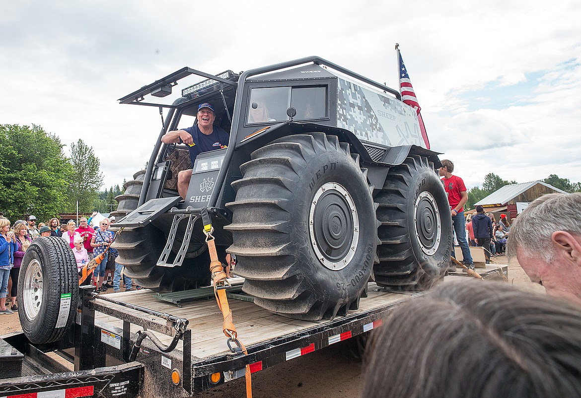 Freedom Bank President Don Bennett throws candy from the super all-terrain Sherp.