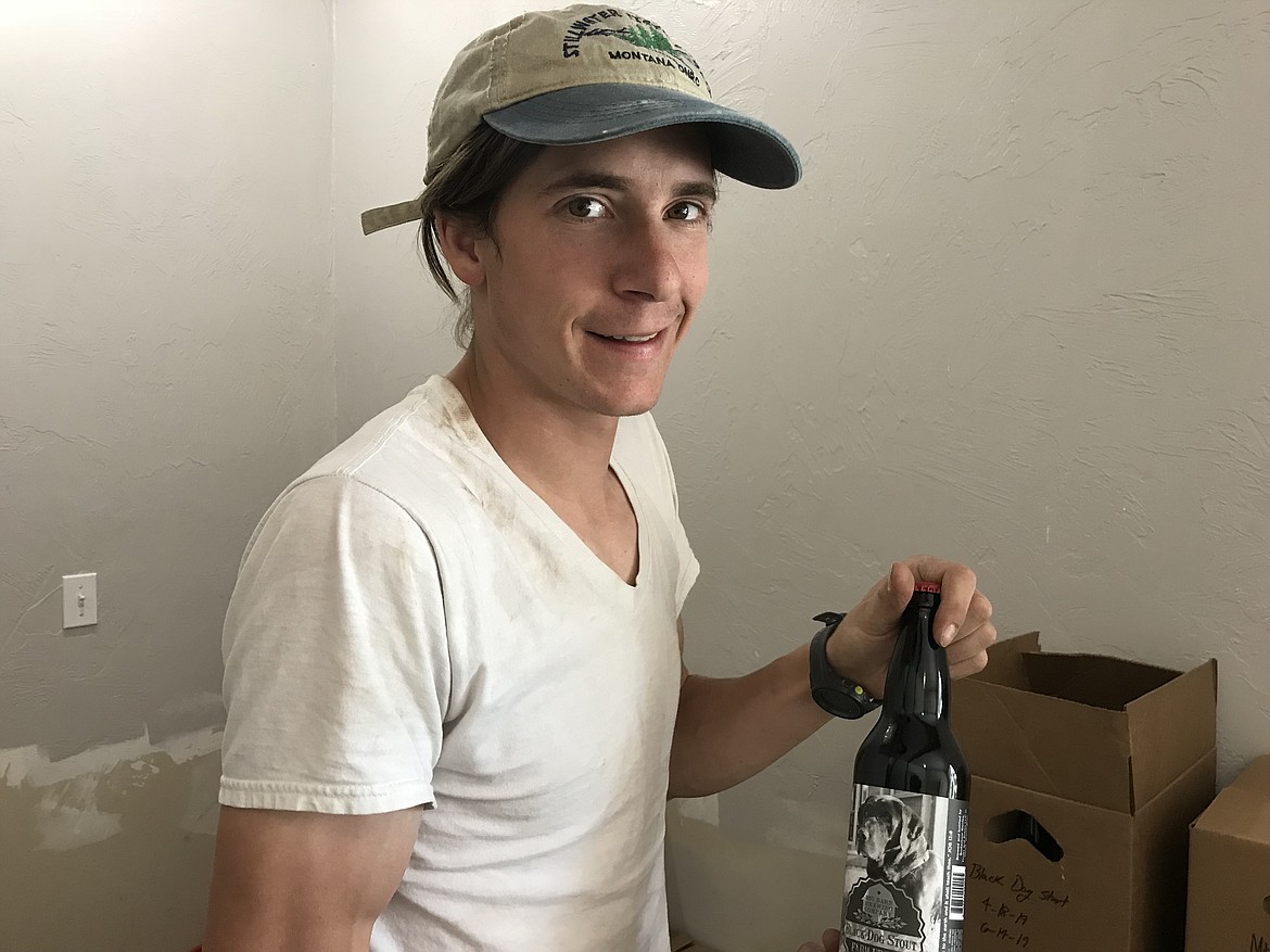 Eli Deitz of Greenbluff&#146;s Big Barn Brewing Co. holds a bottle of Black Dog Stout, named after Nandi, the farm&#146;s black lab.