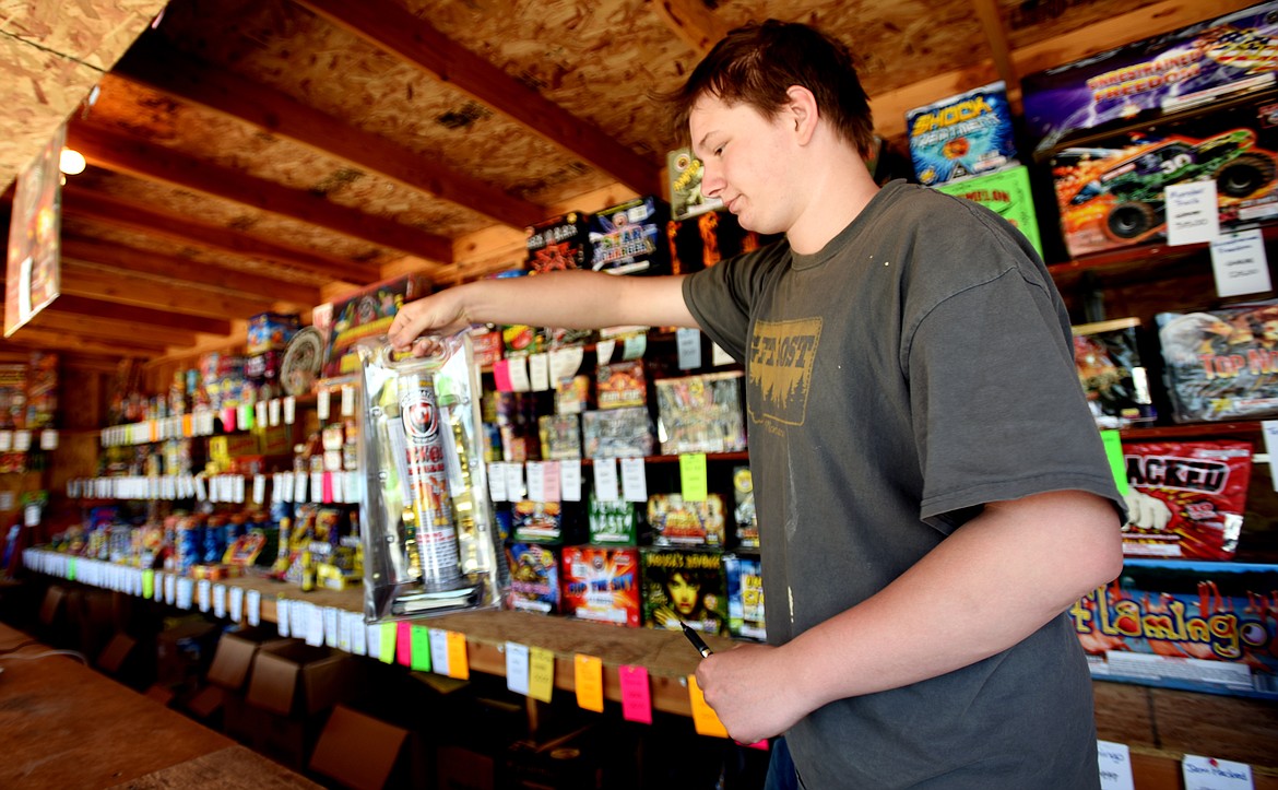 Trey Schrader, 20, brings a package of fireworks to a customer from Canada on Monday, July 1, at the Hong Kong Harry&#146;s Fireworks stand in Happy Valley. This is one of 19 Hong Kong Harry&#146;s stands in the Flathead Valley and one of 62 across Montana.
(Brenda Ahearn/Daily Inter Lake)