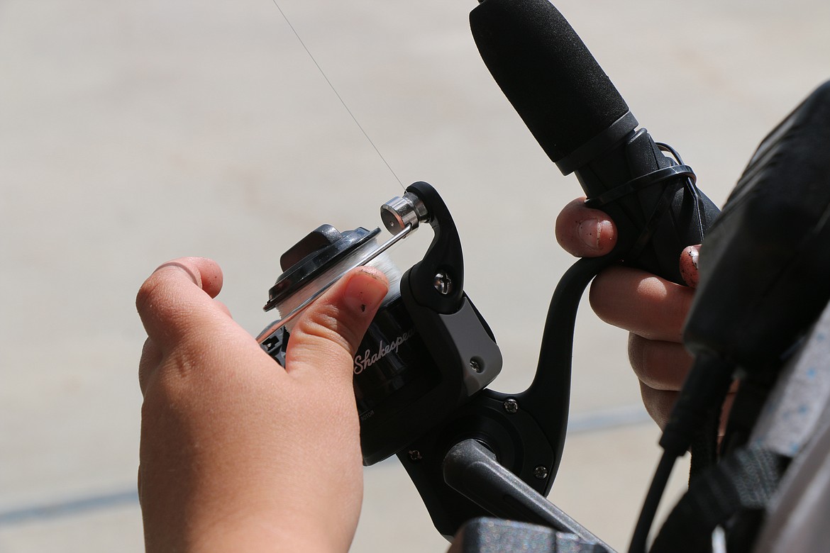 (Photo by CAROLINE LOBSINGER)Max Solis reels in his line while fishing Thursday along Sand Creek in Sandpoint.