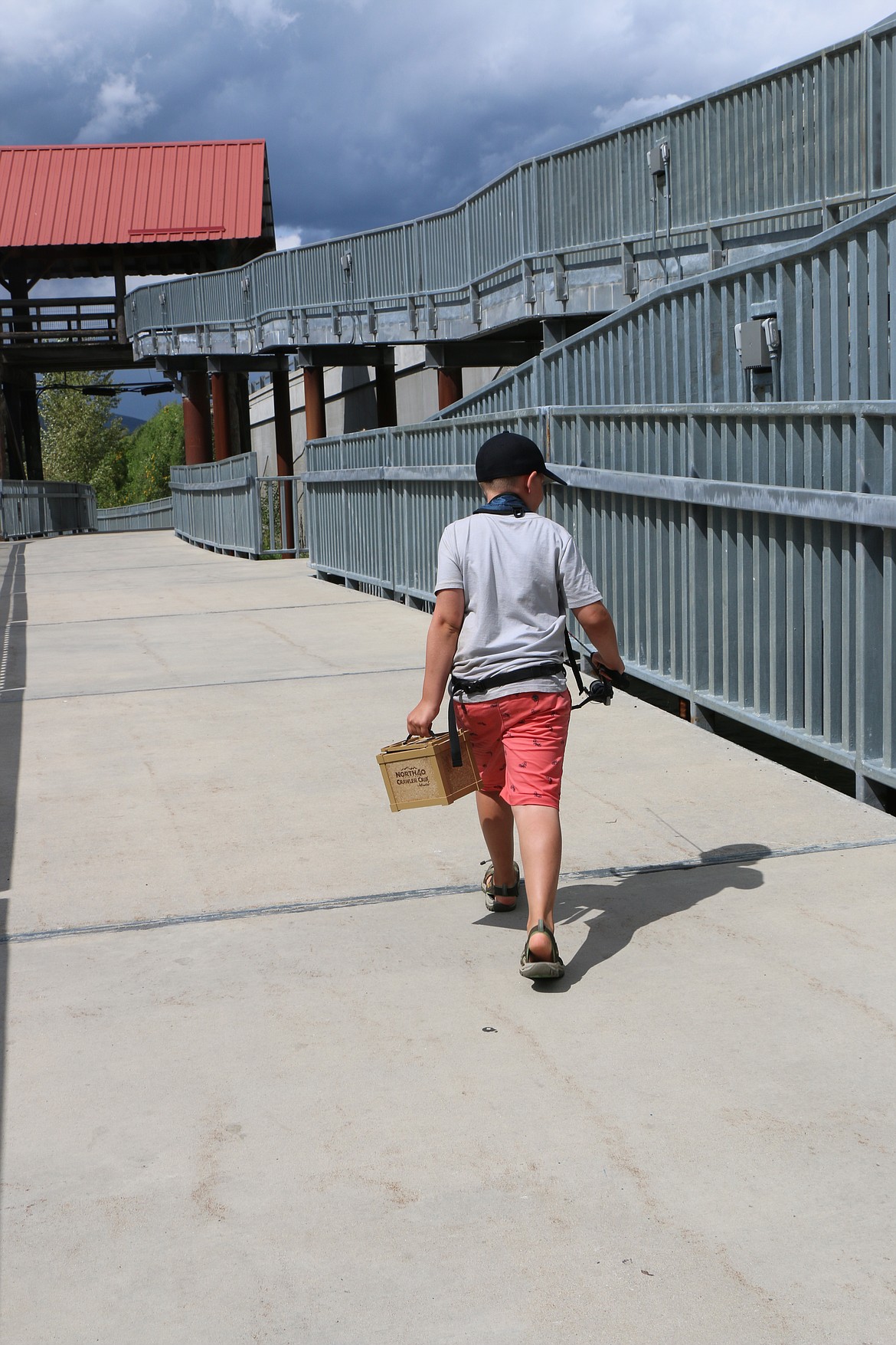 (Photo by CAROLINE LOBSINGER)
Max Solis walks along the boardwalk along Sand Creek&#146;s eastern bank as he heads to his favorite fishing spot by the stairs in search of bass.