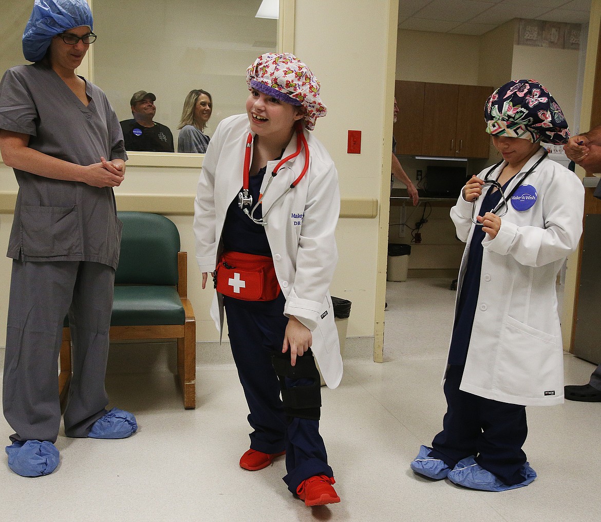 One of the requests of Lizzy Olson's wishes was red shoes because she knows surgeons need to wear shoes that can get dirty in the operating room. On her left is her mom Laura Olson. On her right is her &quot;nurse&quot; sister Katherine. (LOREN BENOIT/Press)