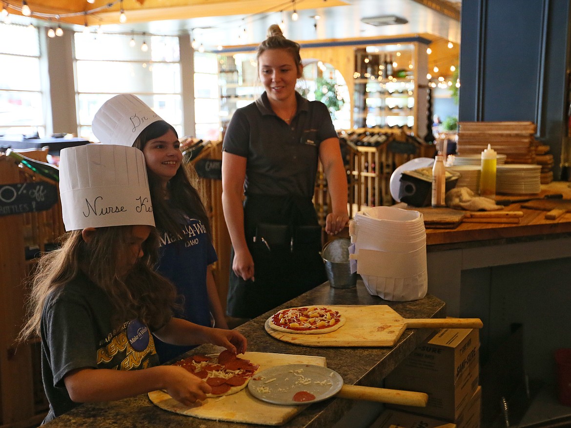 Lizzy Olson, 13, center, and little sis Katherine Olson, 8, make their own pizzas with server Bekah Zufelt on Tuesday evening  at Tito's Italian Grill. The Olson family, of Moscow, stayed a night at The Coeur d'Alene Resort before Make-A-Wish Idaho and Northwest Specialty Hospital gave Lizzy the opportunity to be a surgeon for a day to fulfull her wish. (DEVIN WEEKS/Press)