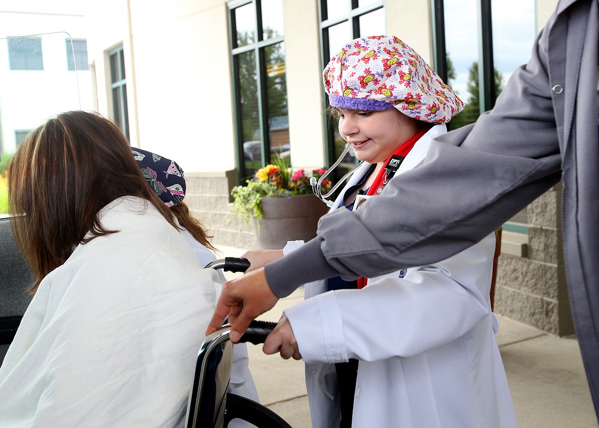 Doctor Lizzy Olson carefully escorts Northwest Specialty&#146;s own nurse, Mary Spratkes, out to her car after being admitted for a minor surgery. Lizzy's wish was to be a surgeon for a day. (LOREN BENOIT/Press)