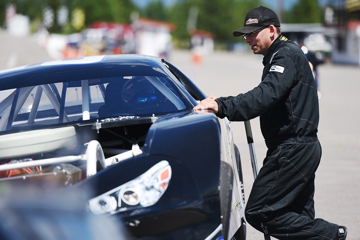 Terry Raymond (12, in car) speaks with fellow driver Logan Jewell (92) in the pit during Super Late Model practice for the Montana 200 at Raceway Park on Thursday. (Casey Kreider/Daily Inter Lake)