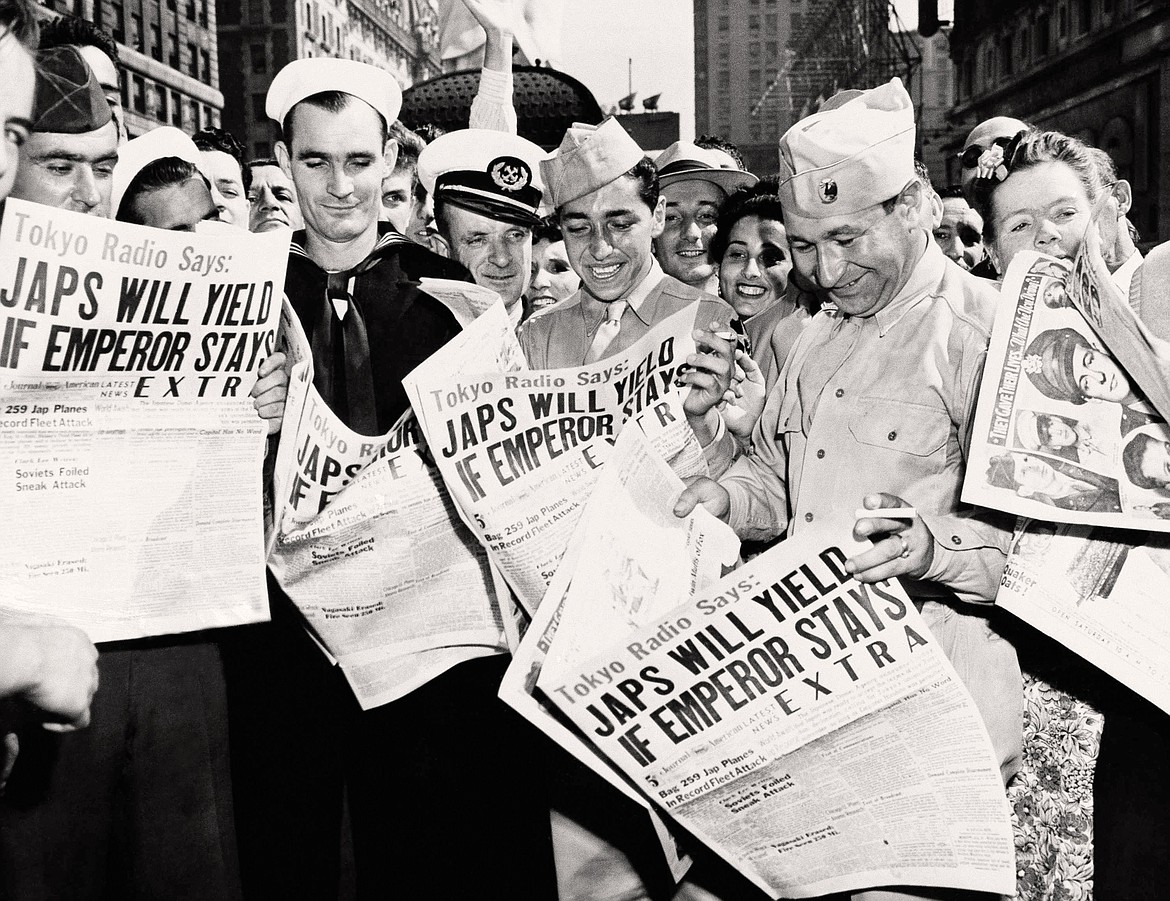 AP PHOTO/Harry Harris
U.S. servicemen reading about Japan&#146;s Emperor Hirohito ordering the acceptance of Allied terms for Japanese surrender.