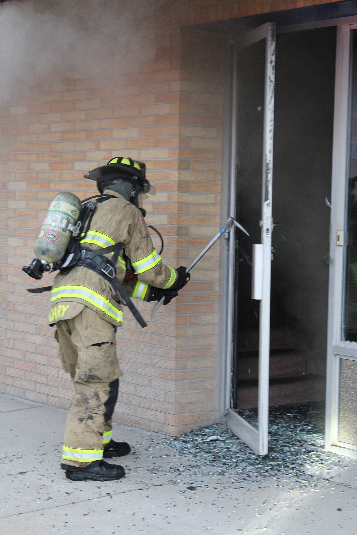 A firefighter gains access to the Re/Max Glacier Country building at the southeast corner of Main and Center in downtown Kalispell. (Duncan Adams/Daily Inter Lake)