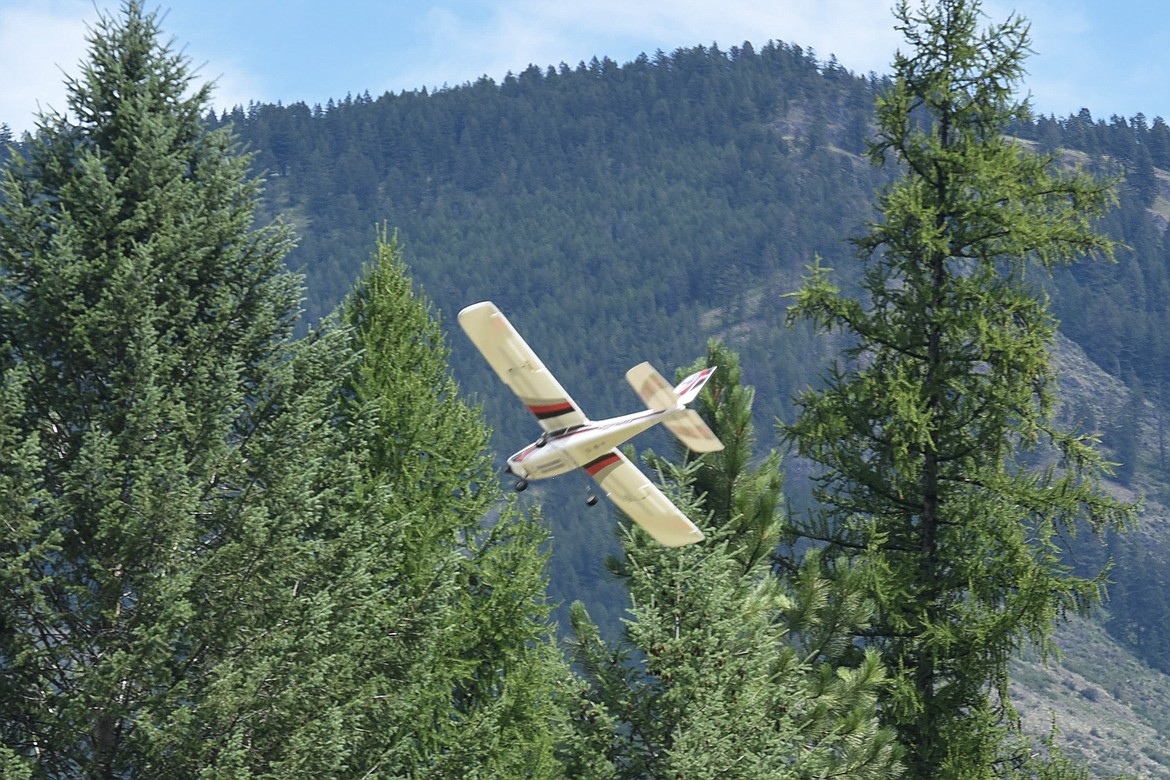 A radio-controlled trainer being flown by Jayce Chandler with assistance from Norm Crum, Saturday at the Kootenai RC Flyers Fun Fly. (Ben Kibbey/The Western News)