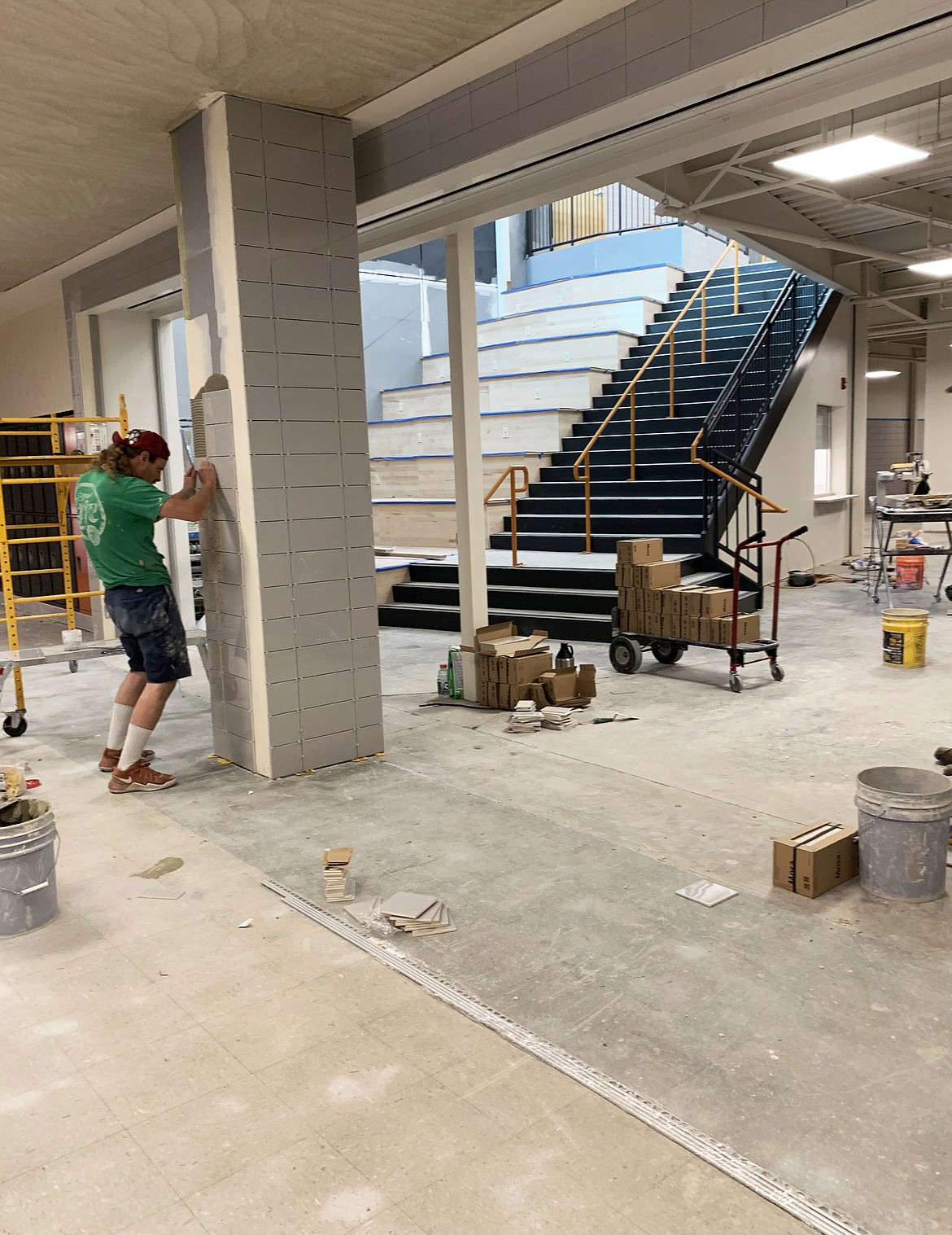 Crews install tiling on Wednesday, July 10, in a section of Flathead High School where existing construction ties into new.