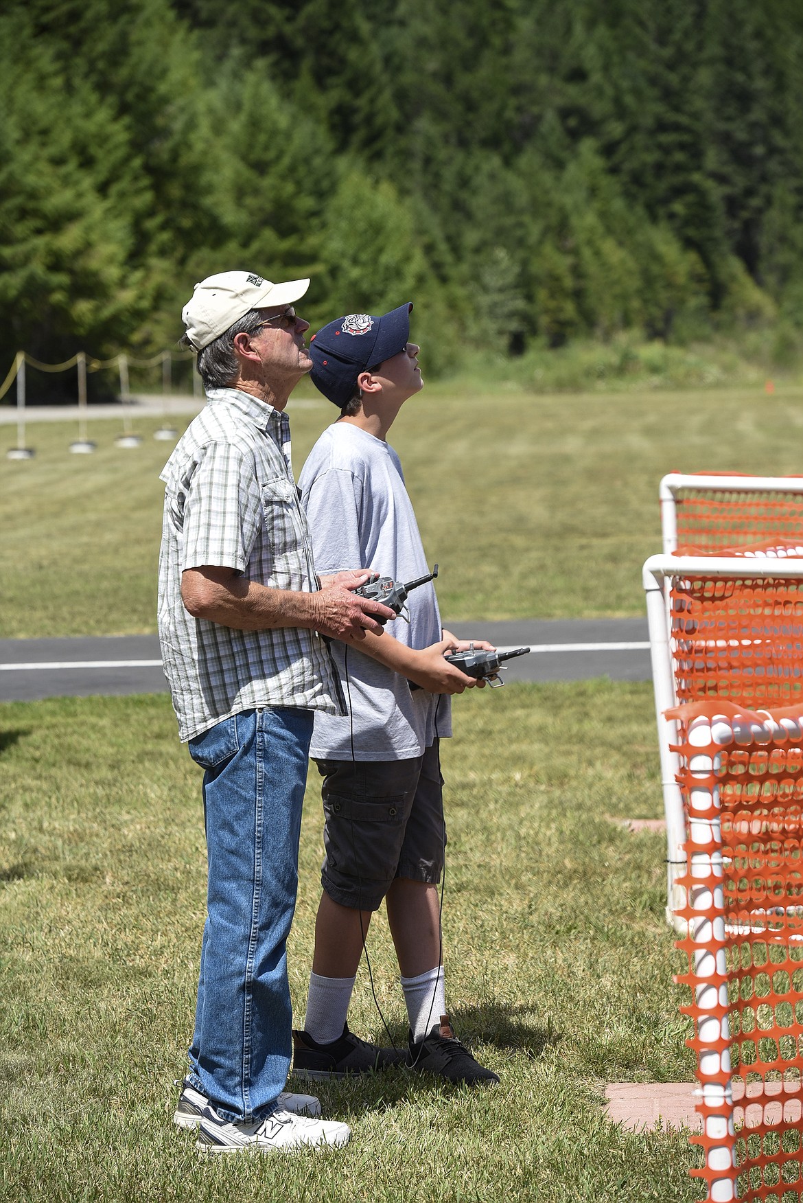 Norm Crum, right, works with Jayce Chandler, a first-time flyer, using dual controllers on one of the club&#146;s trainers, Saturday at the Kootenai RC Flyers Fun Fly. (Ben Kibbey/The Western News)