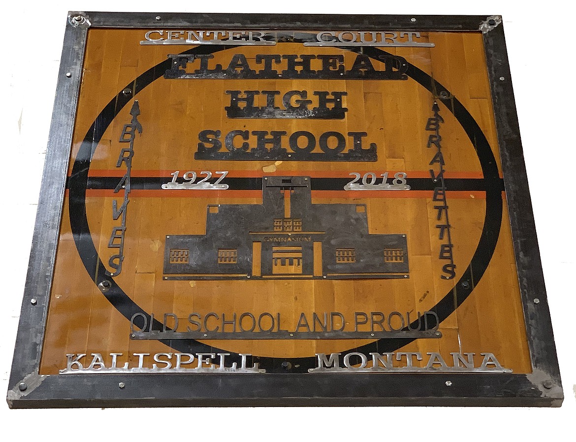 A photo of a plaque that hangs in Flathead High School&#146;s new gym that memorializes the old gym it replaced, which was constructed in the late &#146;20s and demolished in 2018. The plaque was created using flooring preserved from the center court of the old gym. High school welding students made the metalwork.