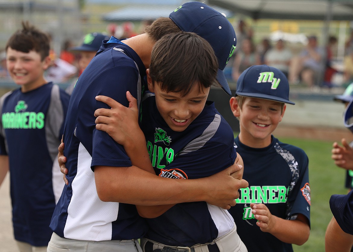 TIAS FYANT gets a congratulatory hug from winning pitcher Cason Graham after Fyant hit a walk-off home run in the bottom of the sixth inning. The 12-U Mission Mariners defeated the Kalispell Lakers 7-6 to capture the 12-U Cal Ripken Western State Montana title in Kalispell Sunday after completing a comeback from a 6-2 deficit. (Photo courtesy of Bob Gunderson)