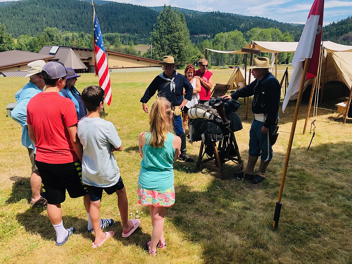 A group gathers to watch the demonstration on how the Frontier Regulars would assemble their saddles before riding out of camp.