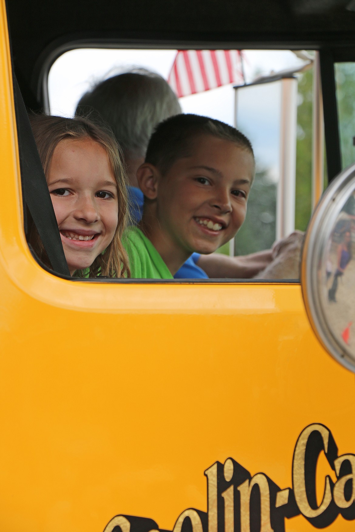 (Photo by CAROLINE LOBSINGER)A pair of youngsters smile as they go for a ride in a firetruck at the Coolin-Cavanaugh Bay Fire Protection District's open house in Priest Lake on Saturday.