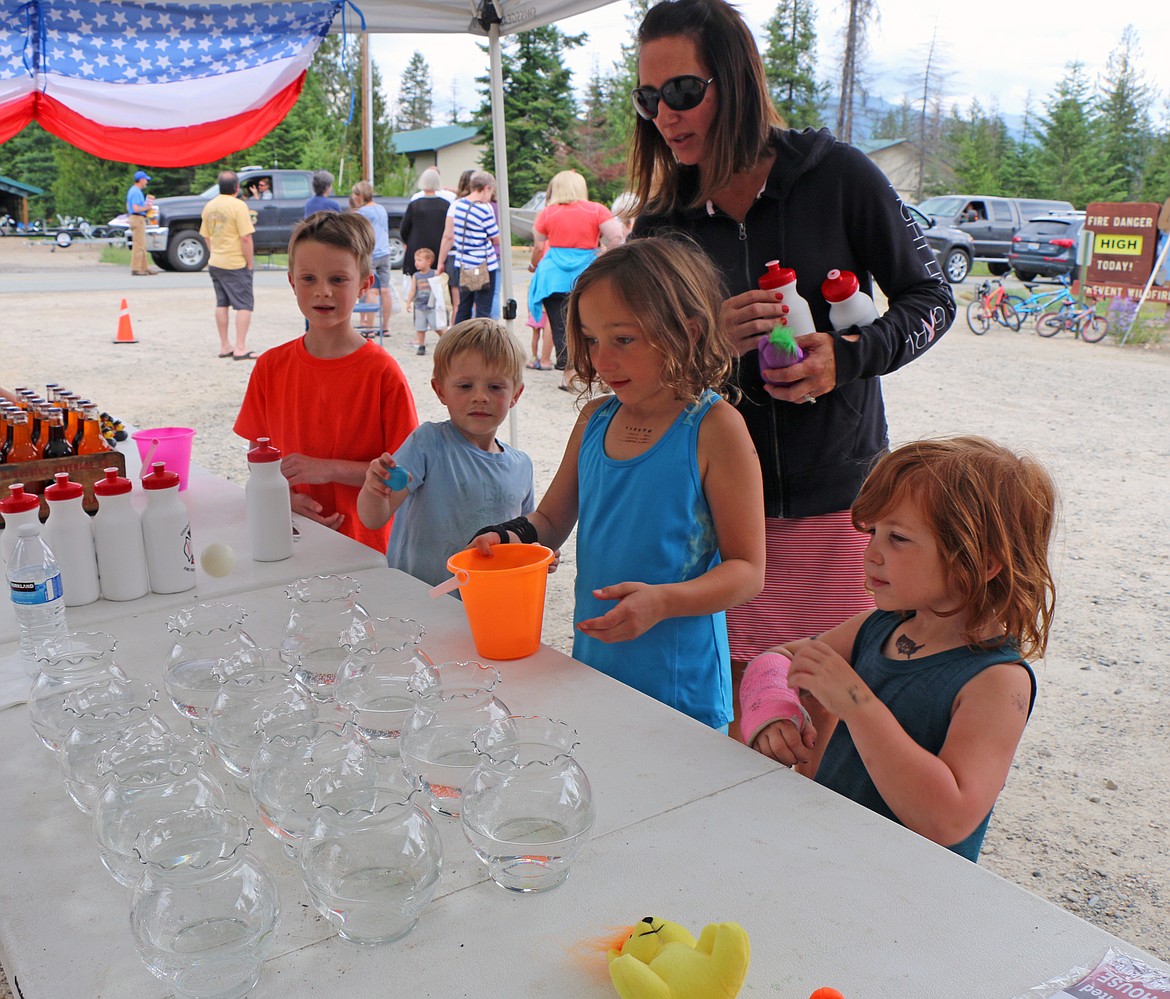 (Photo by CAROLINE LOBSINGER)
Berkley and Neely Schumacher try to toss a ping pong ball into a fish bowl as they have fun at the Coolin-Cavanaugh Bay Fire Protection District&#146;s open house in Priest Lake on Saturday.