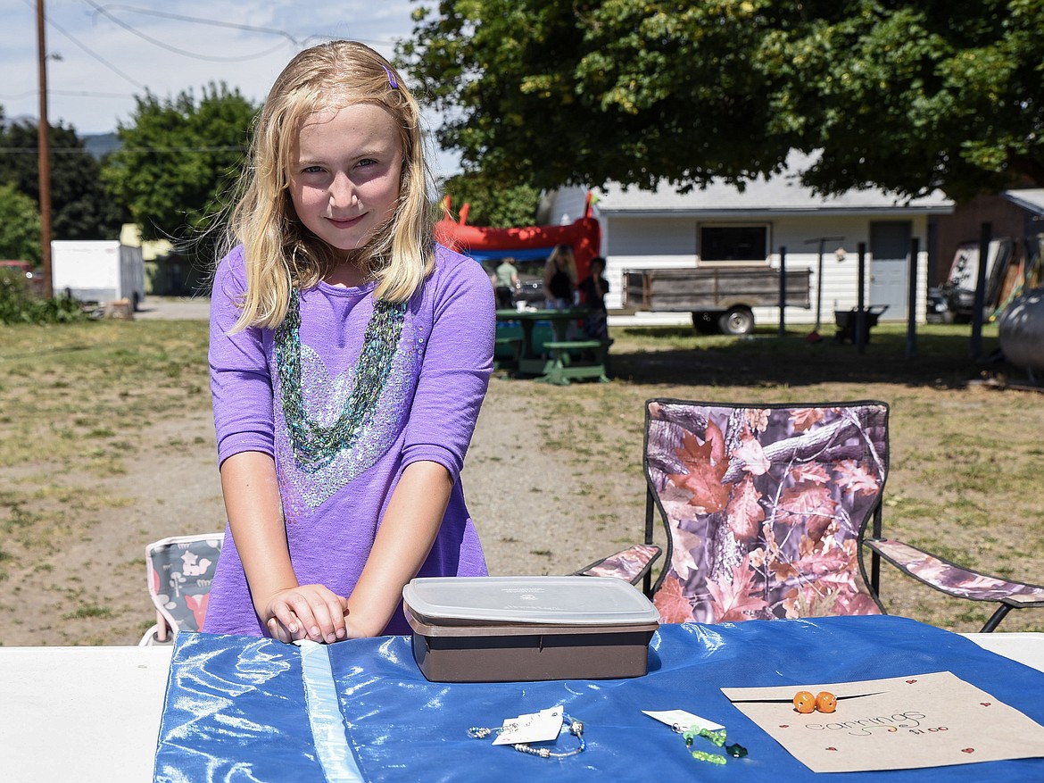 Koehler Holms poses with a few of her handmade jewelry pieces at the Libby Kids' Market next to Hotel Libby, Saturday. An hour in, she had sold most of what she made. Event organizer Kelsey Evans said they plan to do another market on Saturday, Aug. 10. (Ben Kibbey/The Western News)