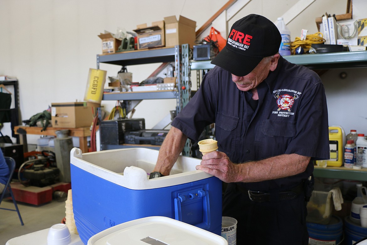 (Photo by CAROLINE LOBSINGER)Mike Nielsen, a member of the Coolin-Cavanaugh Bay Fire Protection District, dishes up ice cream at the fire protection district's open house on Saturday in Priest Lake.