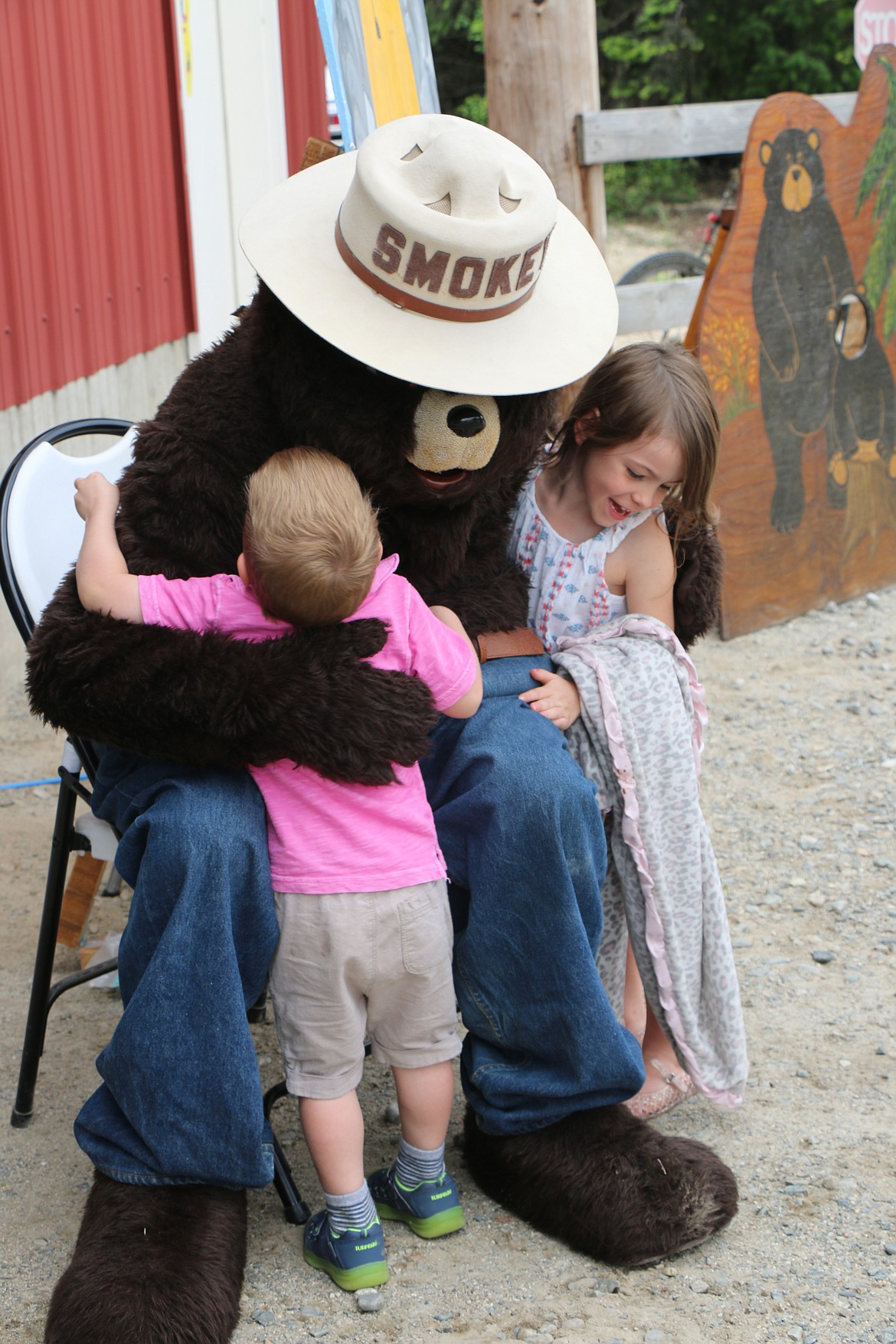 (Photo by CAROLINE LOBSINGER)Maverick and Adelyn Oehlert of Spokane give a big hug to Smokey Bear at the Coolin-Cavanaugh Bay Fire Protection District's open house in Priest Lake on Saturday.